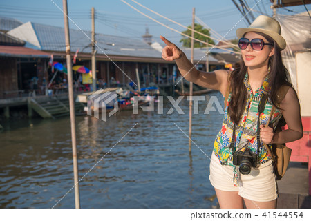 woman stand on river bank and point to the front 41544554