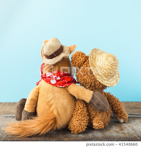 Friendship, teddy bear holding plush horse  41548660