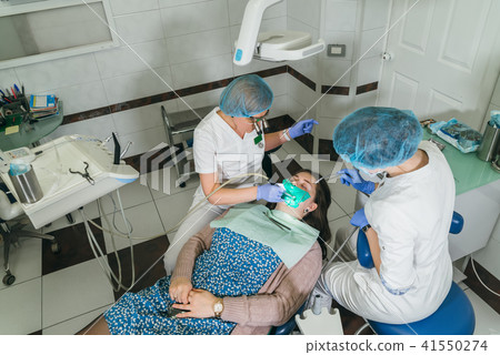 Woman at dentist clinic gets dental treatment to fill a cavity in a tooth. Dental restoration and 41550274