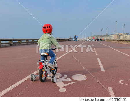 Girl learns riding a four-wheeled bicycle Girl learns riding a four-wheeled bicycle 41550461