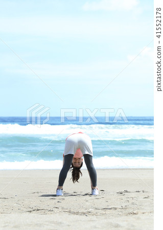 A woman stretching on the coast A woman stretching on the coast 41552178