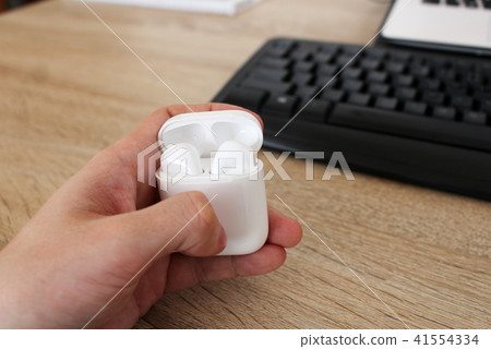 Man holding box with white headphones in office 41554334