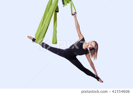 Young woman doing aerial yoga in green hammock. 41554606