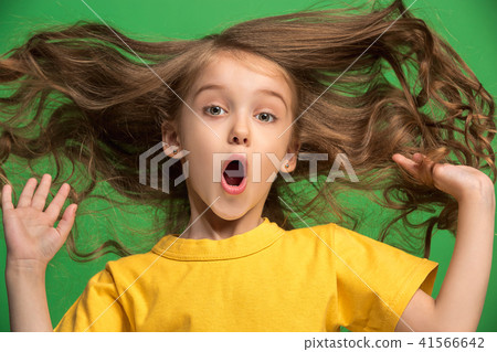Beautiful teen girl looking suprised isolated on green Beautiful teen girl looking suprised isolated on green 41566642