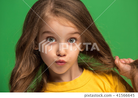 The happy teen girl standing and smiling against green background. The happy teen girl standing and smiling against green background. 41566645