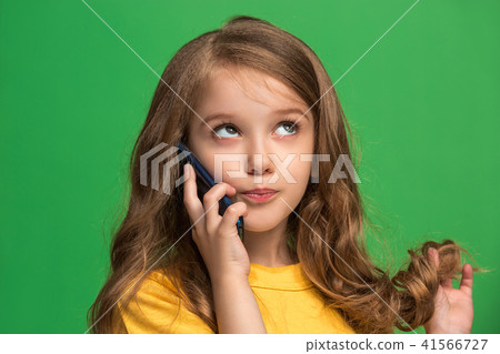 The happy teen girl standing and smiling against green background. The happy teen girl standing and smiling against green background. 41566727