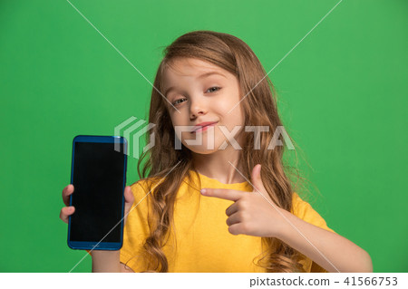 The happy teen girl standing and smiling against green background. 41566753