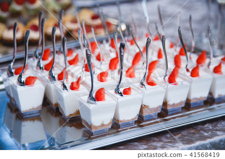 Portion cups with strawberries and cream for a buffet table Portion cups with strawberries and cream for a buffet table 41568419
