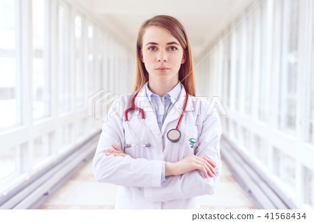 Attractive young female doctor in white coat. Attractive young female doctor in white coat. 41568434