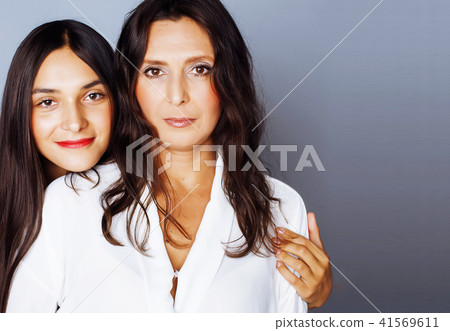 cute pretty teen daughter with mature mother hugging, fashion st cute pretty teen daughter with mature mother hugging, fashion st 41569611