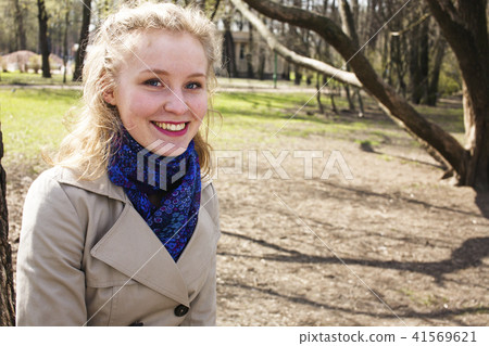 happy blond young woman in green spring park smiling, lifestyle  41569621