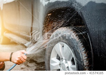 Man washing and cleaning car with spraying pressured water Man washing and cleaning car with spraying pressured water 41574185