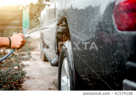 Man washing and cleaning car with spraying pressured water Man washing and cleaning car with spraying pressured water 41574186