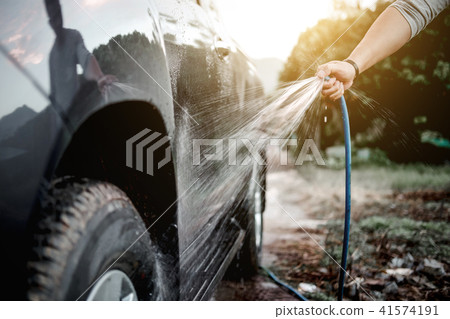 Man washing and cleaning car with spraying pressured water Man washing and cleaning car with spraying pressured water 41574191