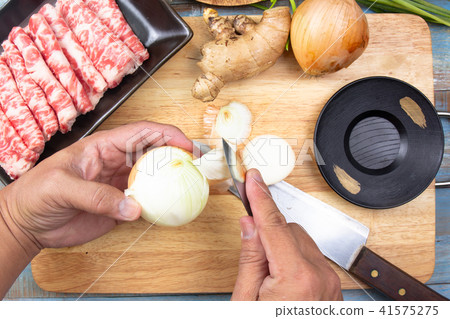 Chef peeling onion before cooking 41575275