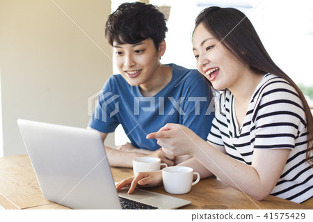 Casual young men and women using personal computers 41575429