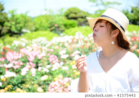 Woman blowing dandelion's fluff Woman blowing dandelion's fluff 41575443