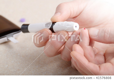 Man Pierce his fingertip before doing blood test 41576808