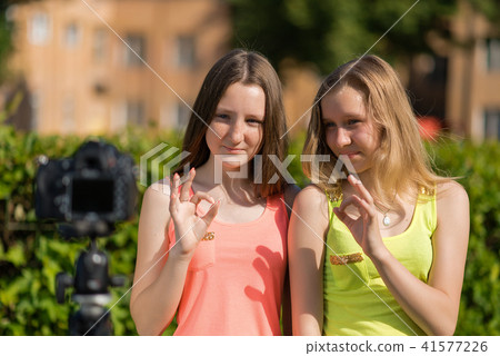 Two girls in the summer in park. Summer in nature. Young girlfriends bloggers showing gestures of Two girls in the summer in park. Summer in nature. Young girlfriends bloggers showing gestures of 41577226