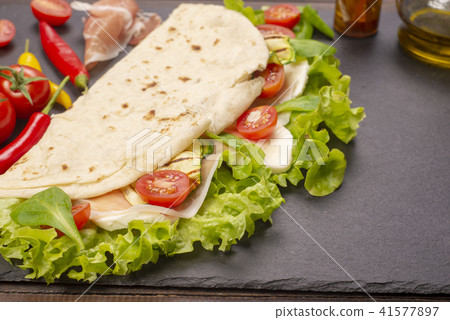 Piadina romagnola with cheese and ham 41577897