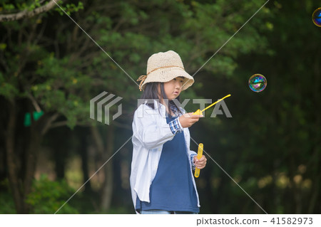 A girl playing with soap bubbles A girl playing with soap bubbles 41582973