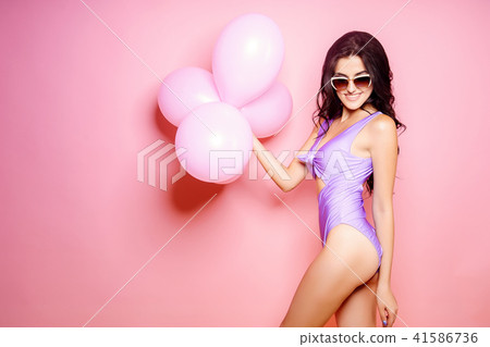 Sexy Lady in bodysuit, sunglasses slim figure, young and healthy posing with balloons on pink 41586736
