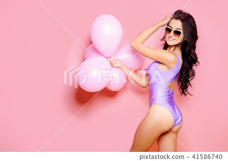 Sexy Lady in bodysuit, sunglasses slim figure, young and healthy posing with balloons on pink 41586740