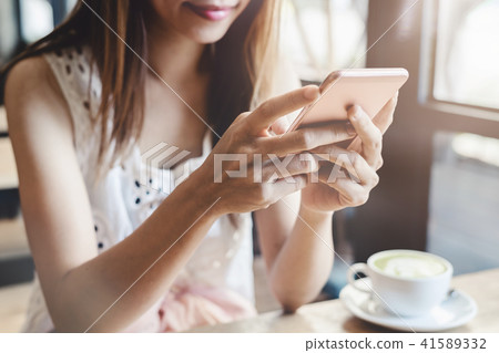 Young woman using smart phone in coffee shop 41589332