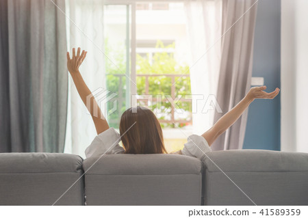 Young woman relaxing on sofa at cozy home 41589359