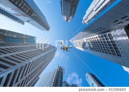 Plane flying over city on blue sky background. Plane flying over city on blue sky background. 41590983