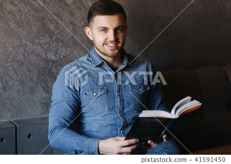 Handsome man with a beard reading a book in a cafe 41591450