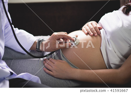 Doctor examining a pregnant woman Doctor examining a pregnant woman 41591667