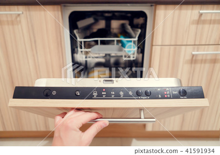 Photo of human's hand opening dishwasher with dirty dishes 41591934