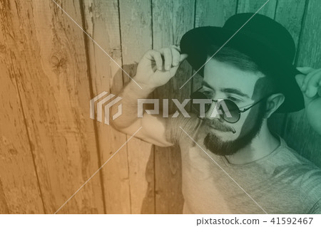 Bearded hipster man in hat and sunglasses Bearded hipster man in hat and sunglasses 41592467