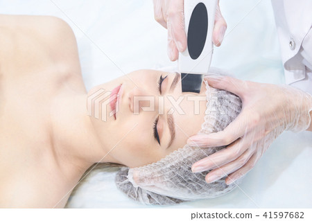 Ultrasonic clean face. Modern equipment.Young girl Ultrasonic clean face. Modern equipment.Young girl 41597682