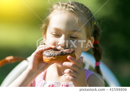 The girl runs along the road with a basket bread. The girl runs along the road with a basket bread. 41599806