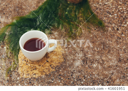 cup of coffee on the sea water and stone cup of coffee on the sea water and stone 41601951