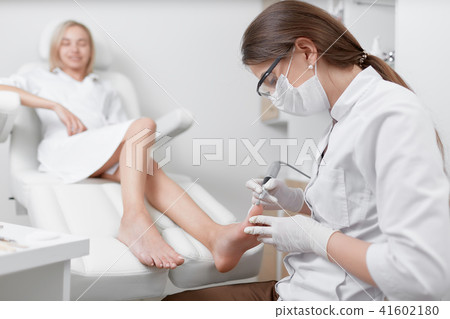 Ppodiatrist making procedure of grinding for happy client. Ppodiatrist making procedure of grinding for happy client. 41602180
