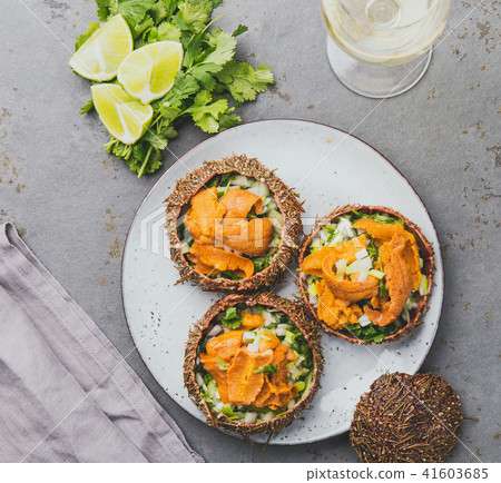 Fresh opened sea urchins. Caviar of sea urchins with onion, cilantro and lemon inside of shell of Fresh opened sea urchins. Caviar of sea urchins with onion, cilantro and lemon inside of shell of 41603685