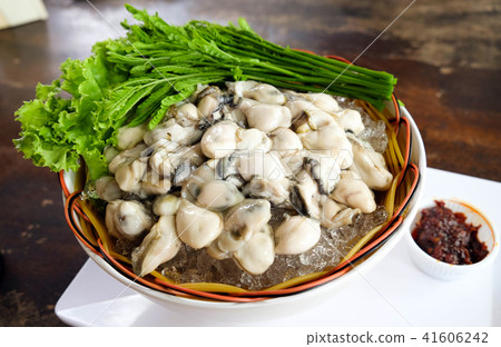 Fresh oysters on ice with acacia in a bowl Fresh oysters on ice with acacia in a bowl 41606242