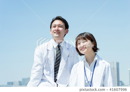 Men and women of white robes looking far away (images of doctors and scientists) 41607996