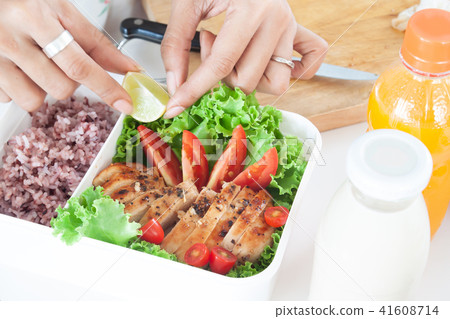 Woman's hands preparing healthy food in lunch box 41608714