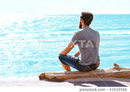 a man sitting on the beach a man sitting on the beach 41610566