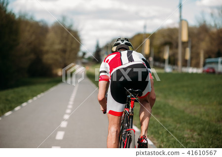 Cyclist rides on bicycle, side view Cyclist rides on bicycle, side view 41610567