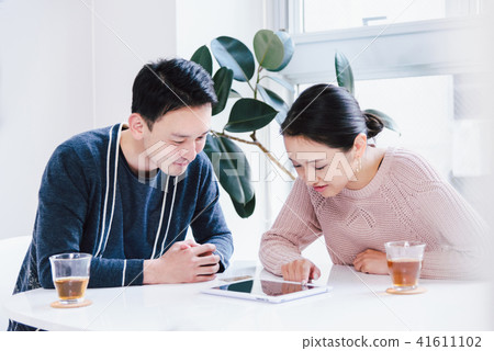 A couple talking while watching a tablet PC 41611102