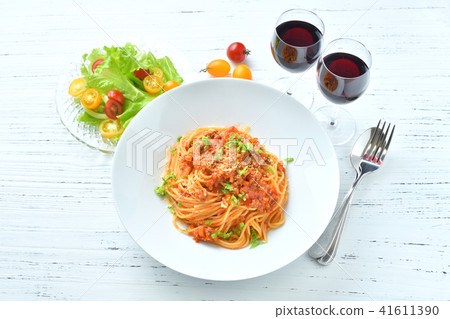 Italian pasta Bolognese. Pasta with minced meat and tomato sauce, spaghetti. With red wine and salad. 41611390