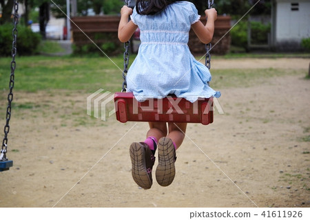 A child playing with a swing in a park A child playing with a swing in a park 41611926