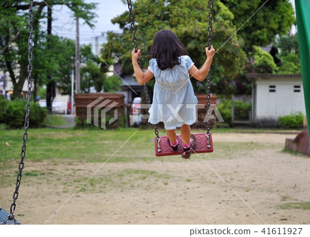 A child playing with a swing in a park A child playing with a swing in a park 41611927