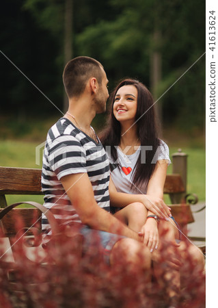 Young couple in love spending time together and sit on the bench Young couple in love spending time together and sit on the bench 41613624