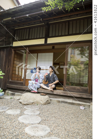 A couple of male and female couples in a yukata eating watermelon on the side of an old private house A couple of male and female couples in a yukata eating watermelon on the side of an old private house 41613822